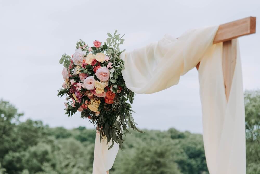 Wedding flowers decoration in peach, pink and white on a pagoda with white material