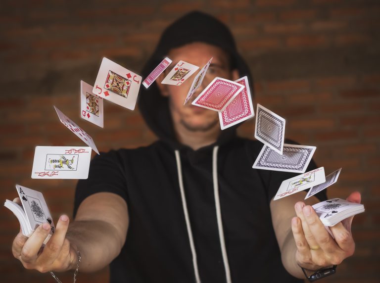 hooded magician playing card tricks