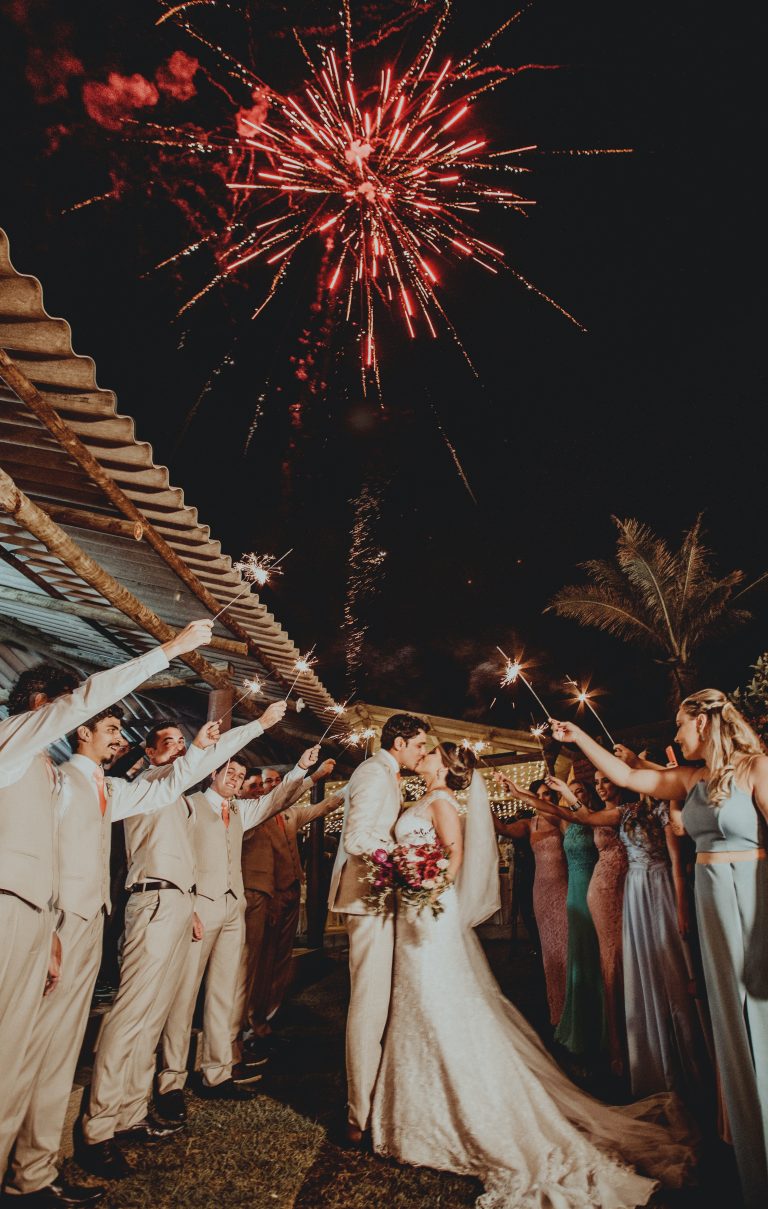 wedding fireworks and sparklers above a kissing bride and groom at night