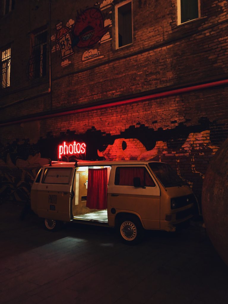 wedding photobooth made from a minivan for weddings and parties with neon light saying photos