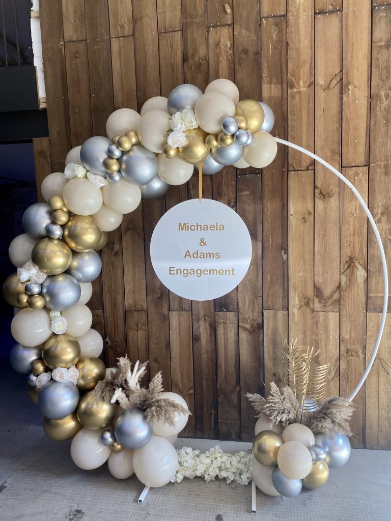 Engagement balloon celebration circle with white, silver and gold balloons adorning the ring