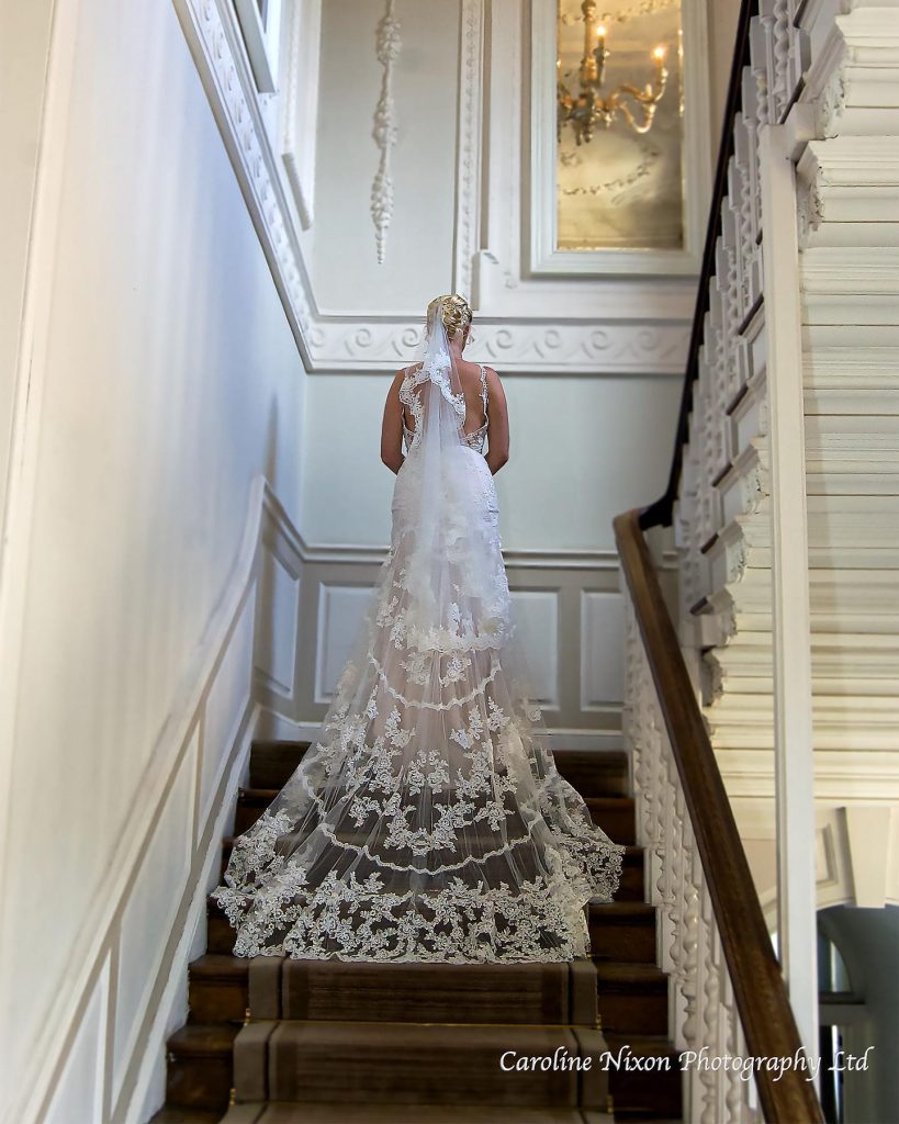 Photogrpahy of bride on a grand stairwell taken by Caroline Nixon Photography