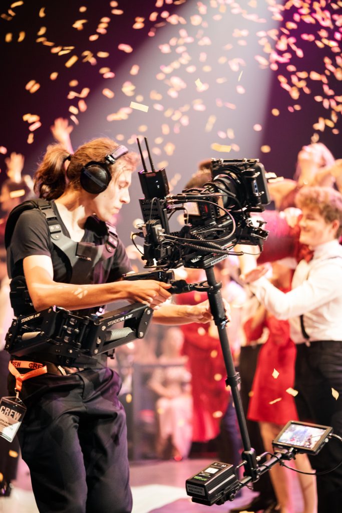 cameraman videoing at a wedding reception with confetti behind