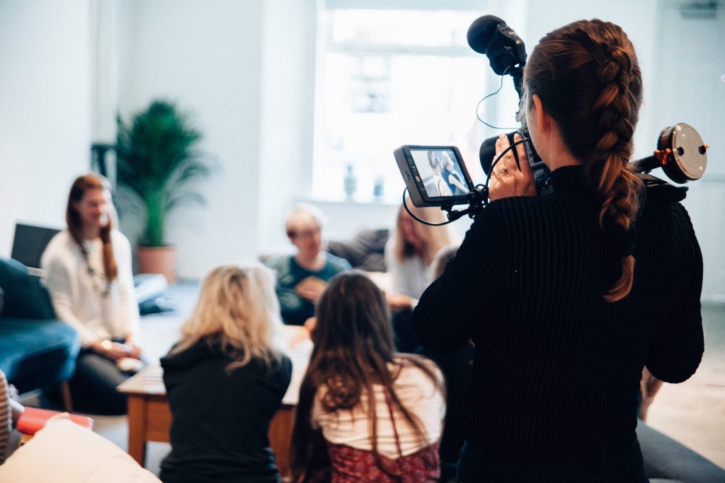 videographer filiming a corporate event session with 5 people in background