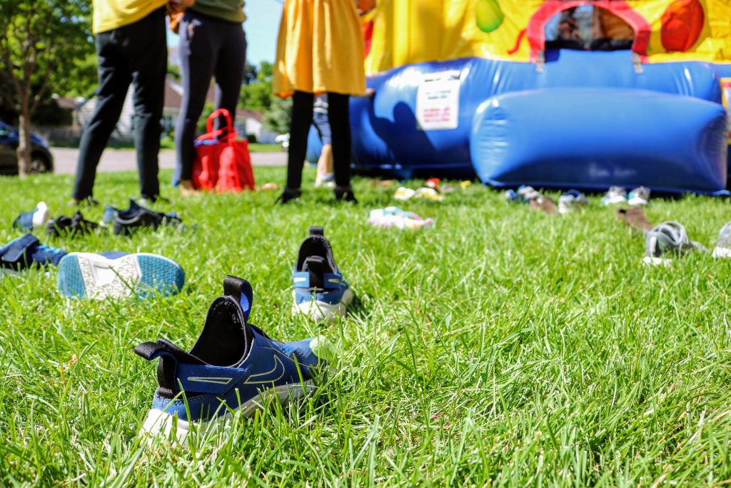shoes on garden grass in front of bouncy castle