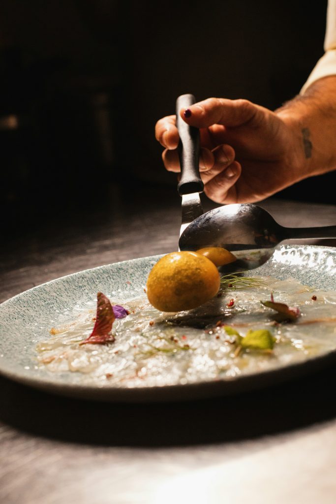 Chef laying find dining food on a white plate